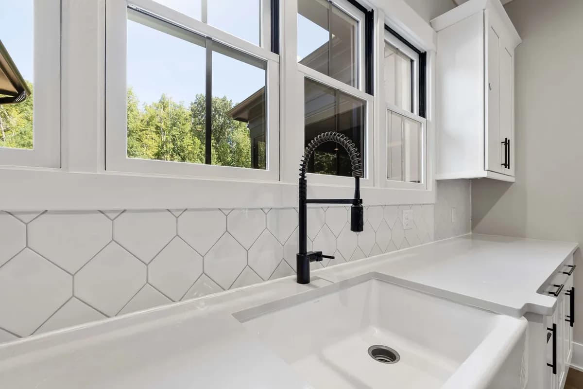 White farmhouse kitchen sink with a black faucet