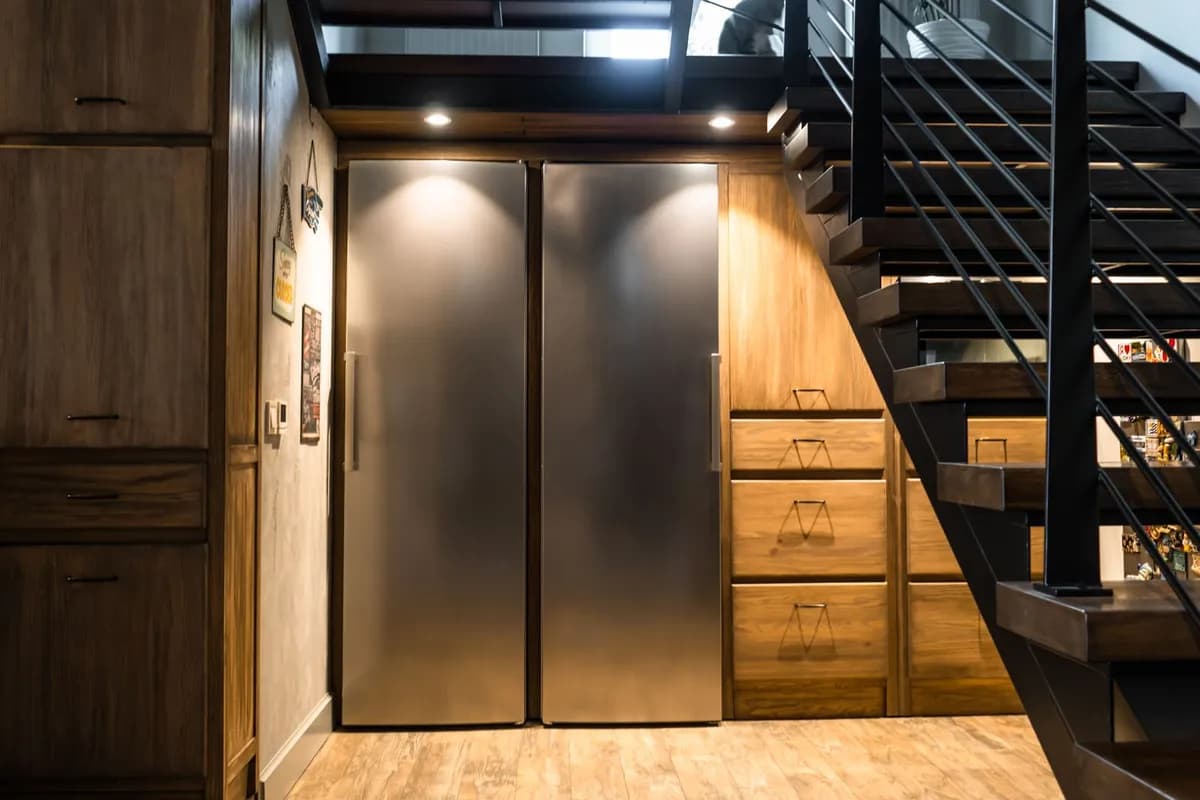Built-in stainless refrigerator and freezer columns in a wood-panelled kitchen